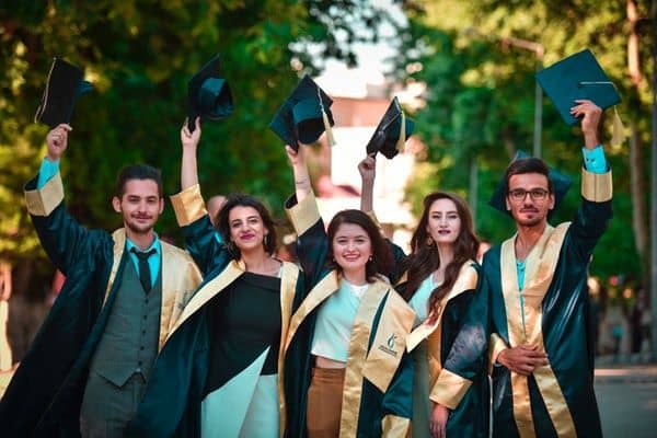 the graduates raising their graduation caps 
